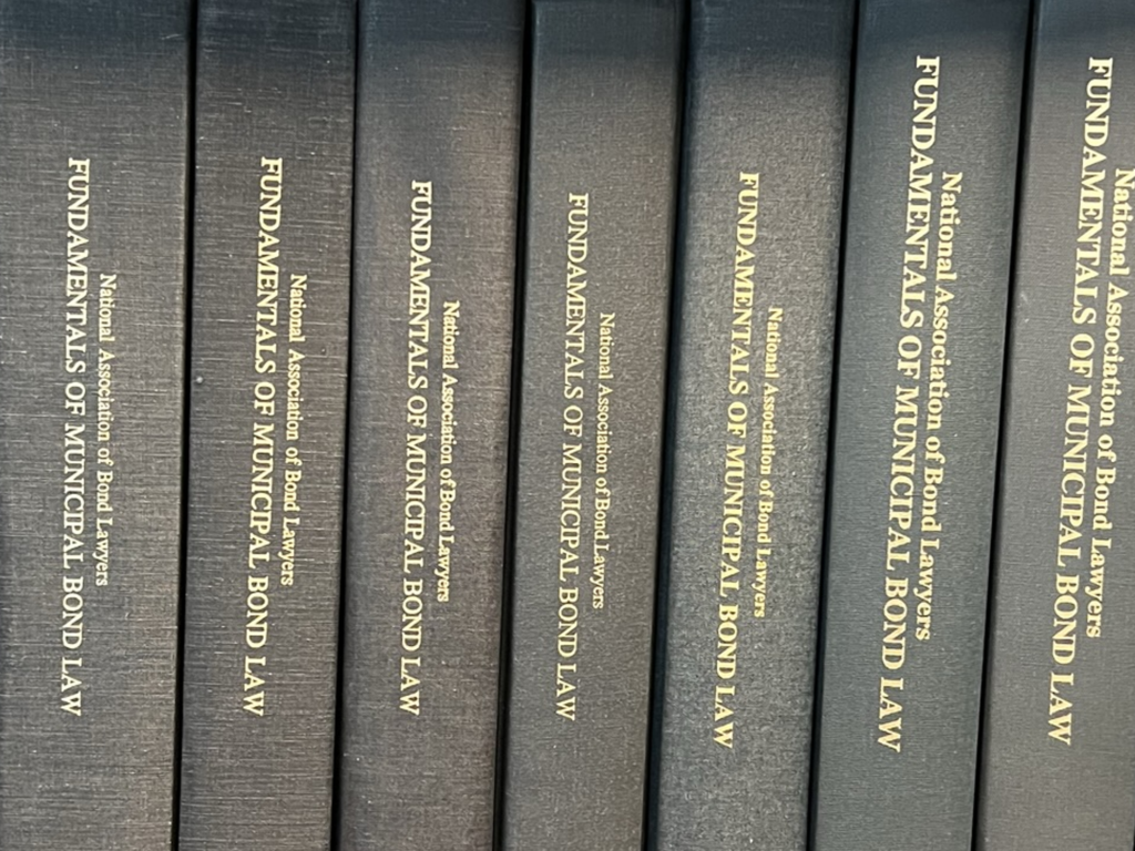 Book spines of the NABL Fundamentals on a book shelf.